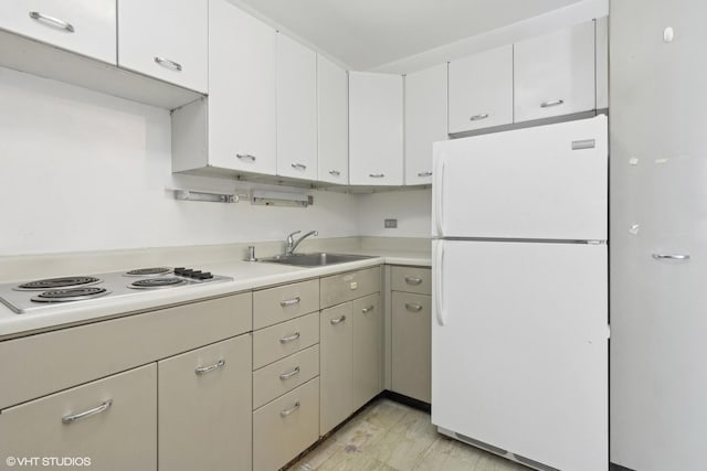 kitchen with white appliances, white cabinetry, and sink