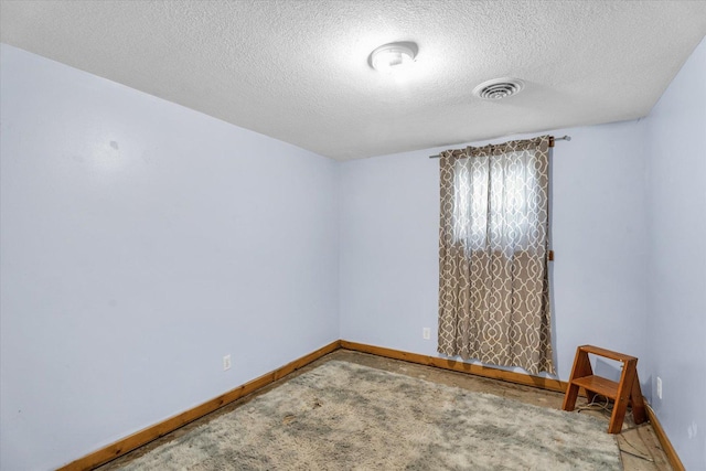 carpeted spare room featuring a textured ceiling