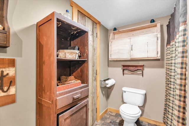 bathroom with toilet and a textured ceiling