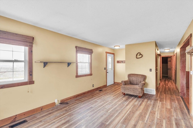 unfurnished room with hardwood / wood-style flooring and a textured ceiling