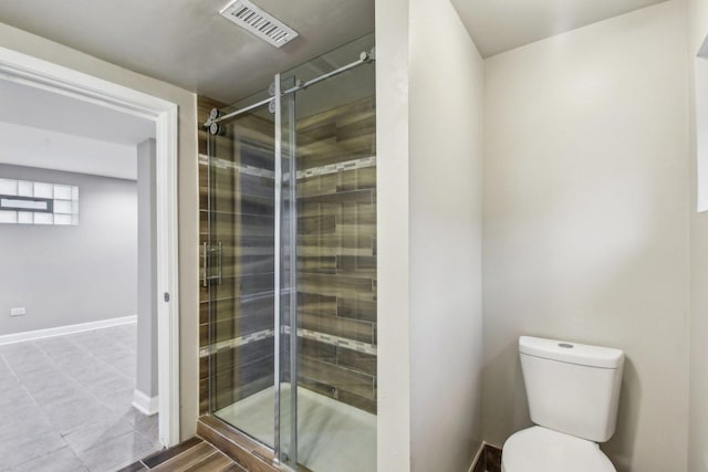 bathroom with toilet and a shower with door