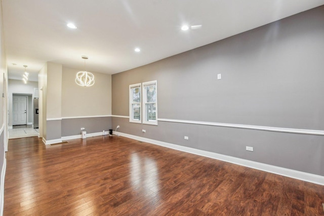 unfurnished room featuring dark hardwood / wood-style flooring and a chandelier