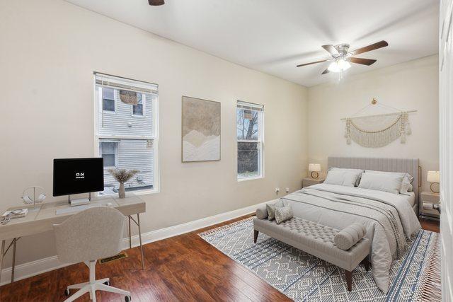 bedroom with multiple windows, ceiling fan, and hardwood / wood-style flooring