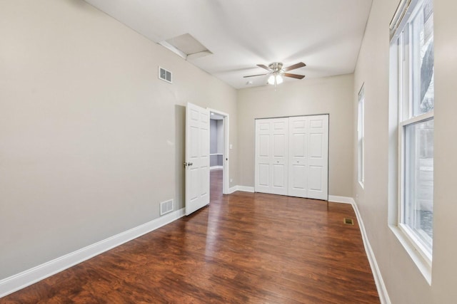 unfurnished bedroom featuring ceiling fan, dark wood-type flooring, and a closet