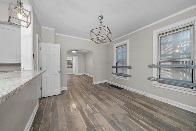 unfurnished dining area with crown molding and dark wood-type flooring