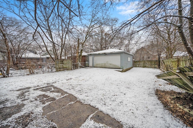 yard covered in snow with a garage and an outdoor structure