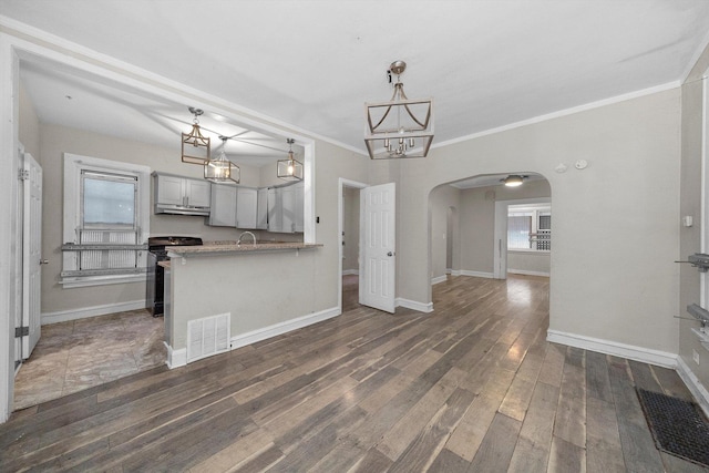 kitchen with dark wood-type flooring, hanging light fixtures, black electric range oven, kitchen peninsula, and ornamental molding