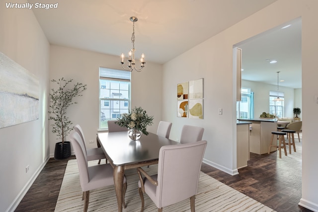 dining space with dark hardwood / wood-style flooring and a notable chandelier