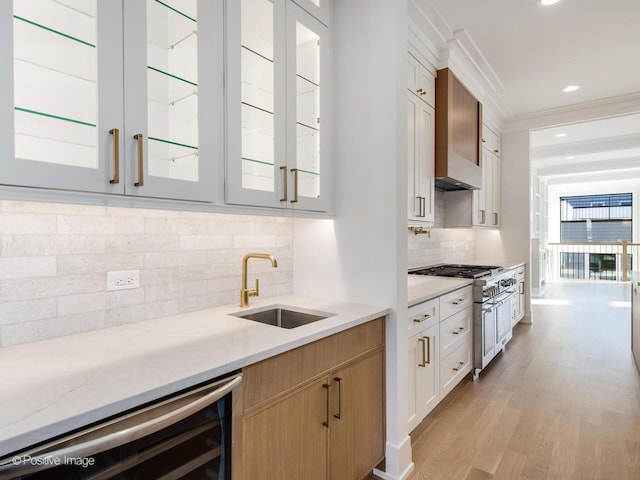 kitchen with sink, wine cooler, decorative backsplash, light hardwood / wood-style floors, and white cabinetry