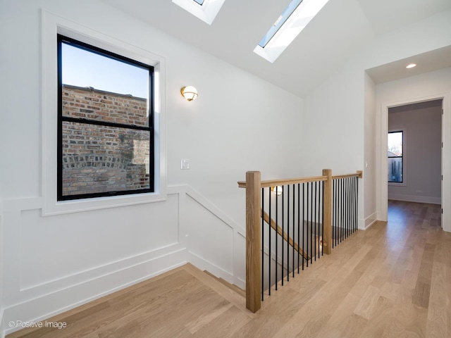 hallway featuring lofted ceiling and light wood-type flooring