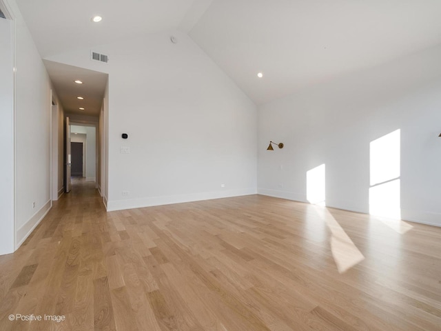 empty room featuring light hardwood / wood-style flooring and high vaulted ceiling