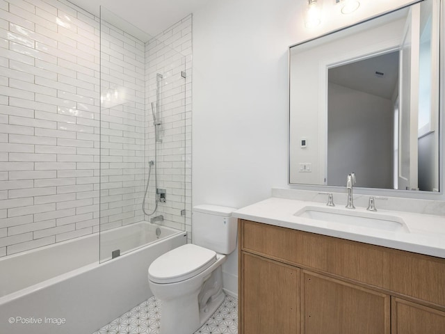 full bathroom featuring vanity, tiled shower / bath combo, and toilet