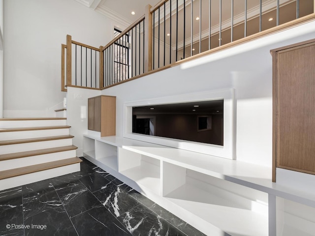 stairs featuring a high ceiling and crown molding