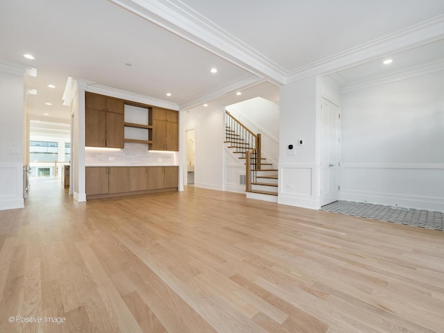 unfurnished living room with light hardwood / wood-style floors and ornamental molding