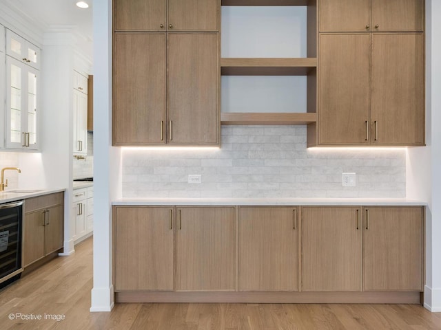 kitchen with decorative backsplash, light brown cabinetry, and light wood-type flooring