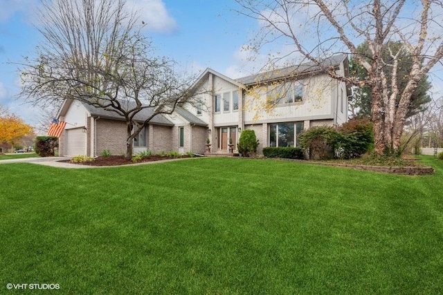 view of front of home featuring an attached garage, a front lawn, and brick siding