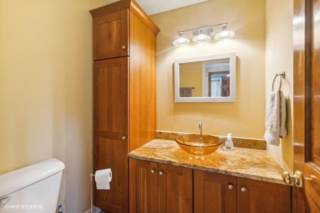 half bathroom featuring vanity and toilet