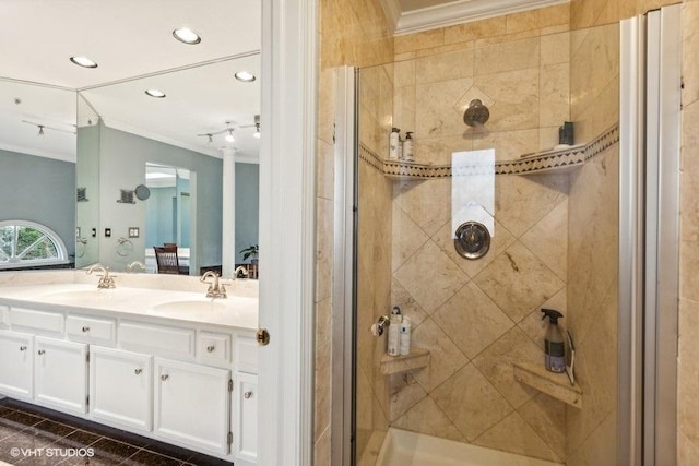 full bathroom with a stall shower, crown molding, and a sink