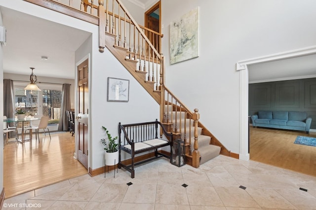 staircase featuring a high ceiling, wood finished floors, and baseboards