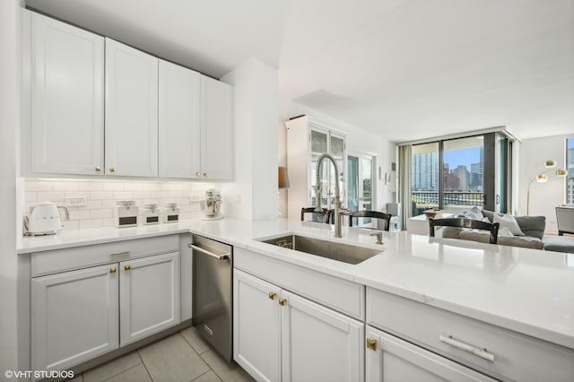 kitchen featuring decorative backsplash, dishwasher, white cabinetry, and sink