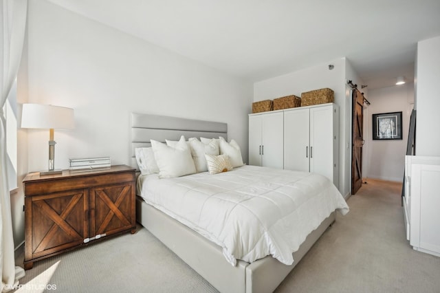 carpeted bedroom featuring a barn door