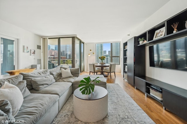 living room featuring floor to ceiling windows and light wood-type flooring