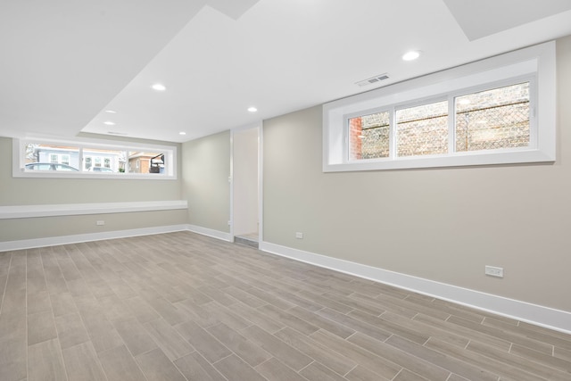 basement featuring light wood-type flooring and a healthy amount of sunlight