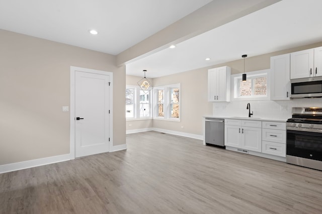 kitchen with white cabinets, pendant lighting, and appliances with stainless steel finishes