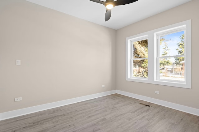 empty room with ceiling fan and light hardwood / wood-style floors