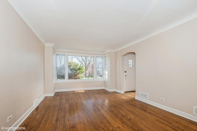 spare room featuring hardwood / wood-style flooring and ornamental molding