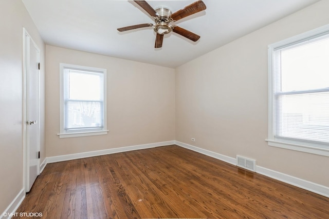 empty room with dark hardwood / wood-style floors and ceiling fan