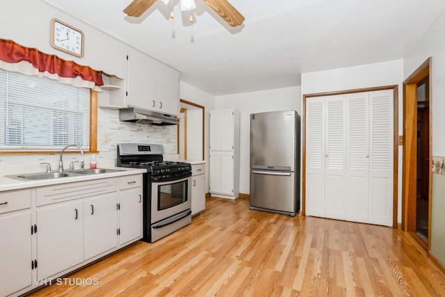 kitchen with white cabinetry, sink, stainless steel appliances, decorative backsplash, and light wood-type flooring