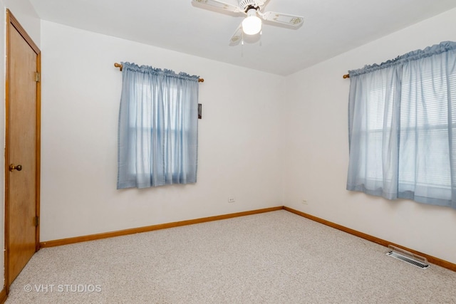 empty room with plenty of natural light, ceiling fan, and carpet floors