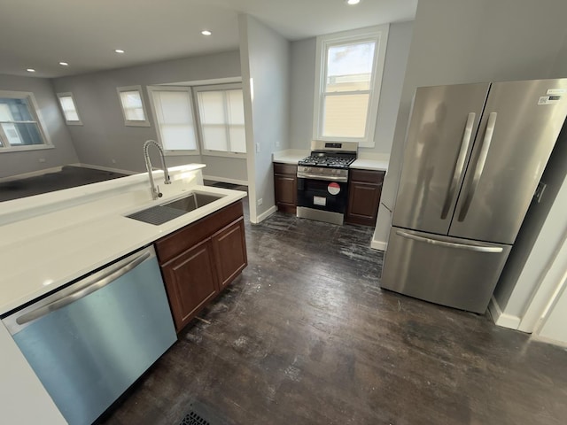 kitchen featuring dark brown cabinetry, sink, and appliances with stainless steel finishes