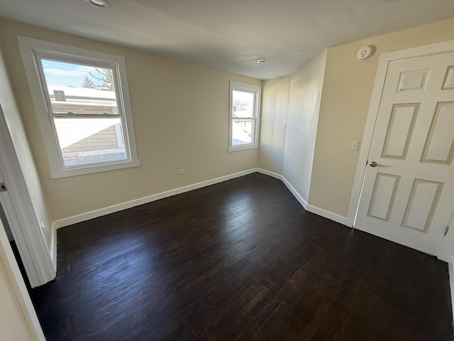 unfurnished room with dark hardwood / wood-style floors and plenty of natural light