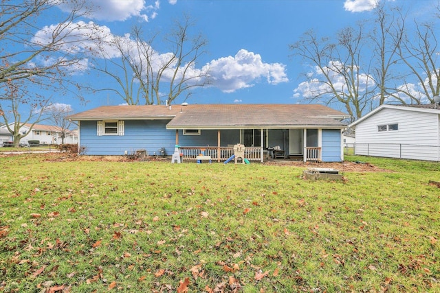 rear view of house with a sunroom and a lawn