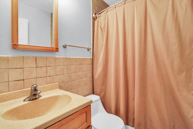 bathroom with vanity, tile walls, and toilet