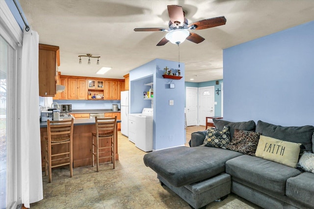 living room with separate washer and dryer and ceiling fan