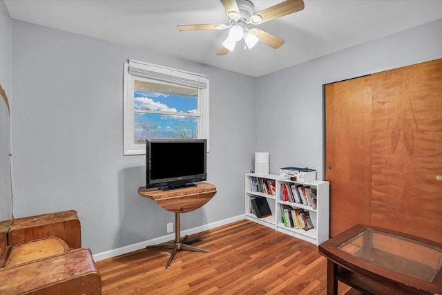 sitting room with hardwood / wood-style floors and ceiling fan