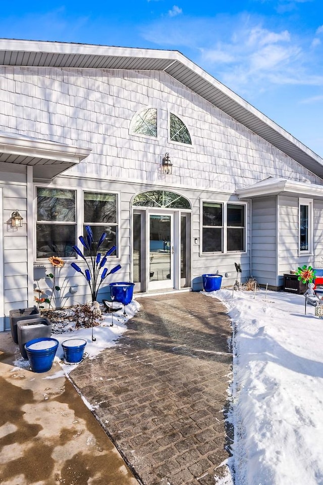 snow covered property entrance with a patio