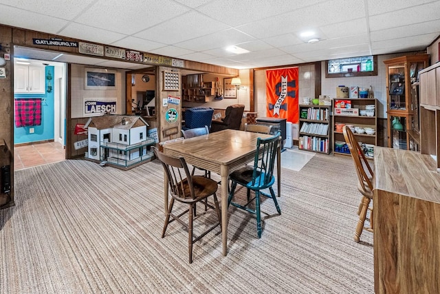 dining room with a paneled ceiling and light colored carpet