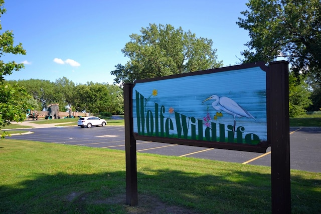 community / neighborhood sign featuring a yard