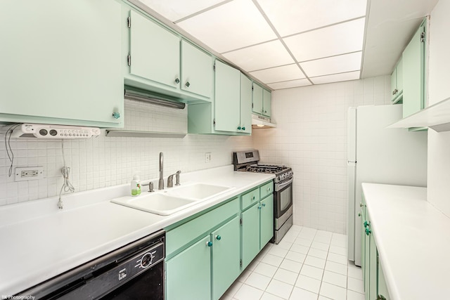 kitchen featuring gas stove, sink, black dishwasher, green cabinets, and light tile patterned floors