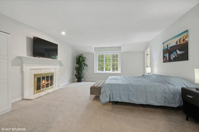 carpeted bedroom with a premium fireplace