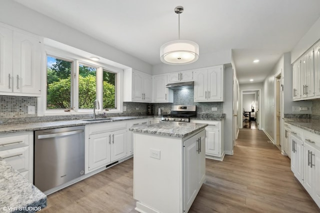 kitchen featuring a kitchen island, white cabinetry, appliances with stainless steel finishes, and sink