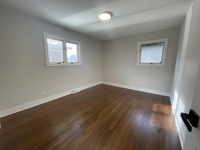 spare room featuring dark wood-type flooring