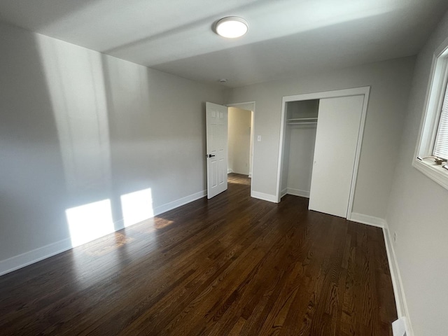 unfurnished bedroom featuring a closet and dark hardwood / wood-style floors