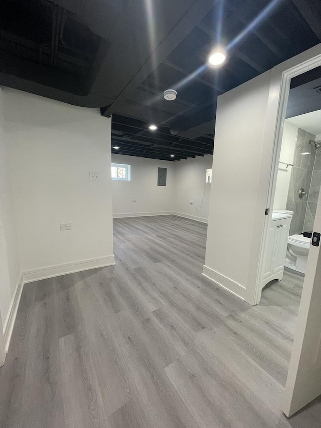 basement with light hardwood / wood-style flooring