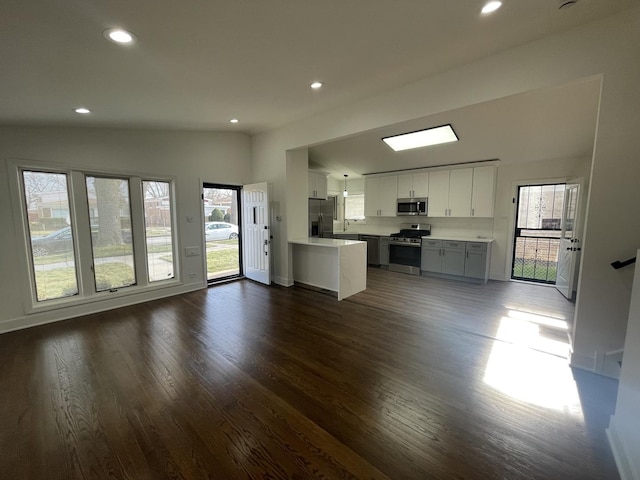 unfurnished living room featuring lofted ceiling and dark hardwood / wood-style floors