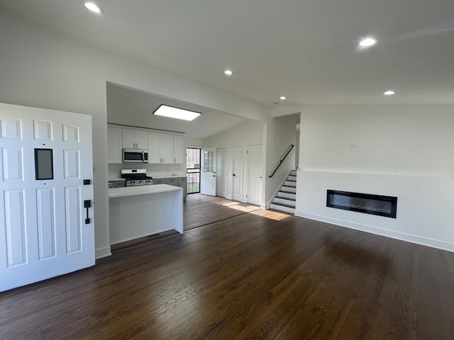 kitchen with white cabinetry, dark hardwood / wood-style flooring, lofted ceiling, and appliances with stainless steel finishes